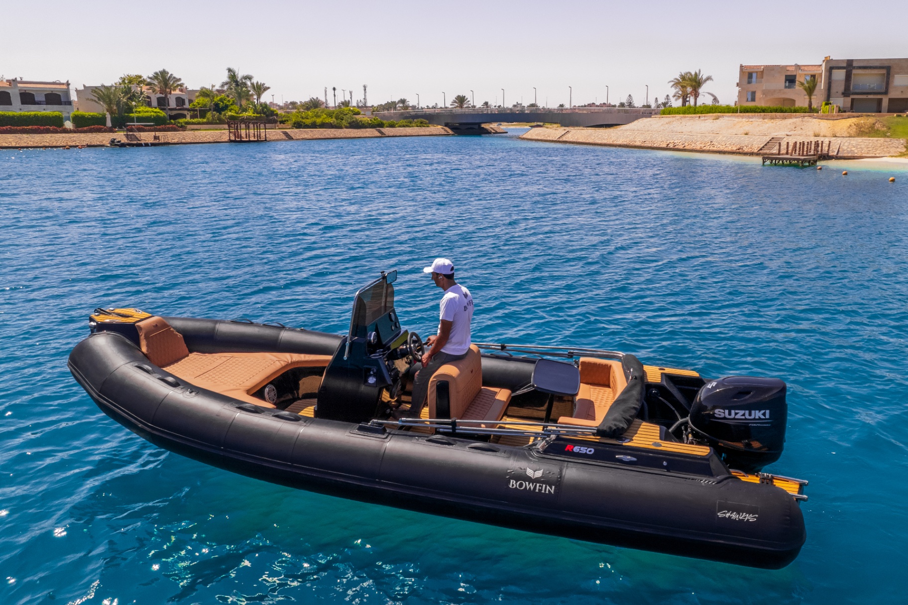 Captain at the helm of Bowfin R650 leaving marina
